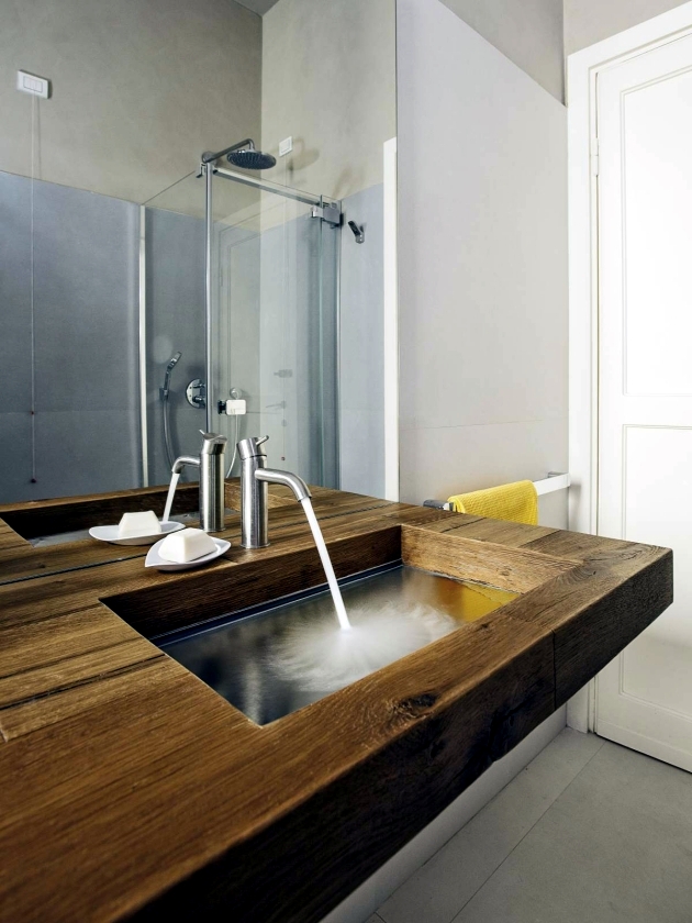 A wood vanity with glass basin of Lake creates illusions