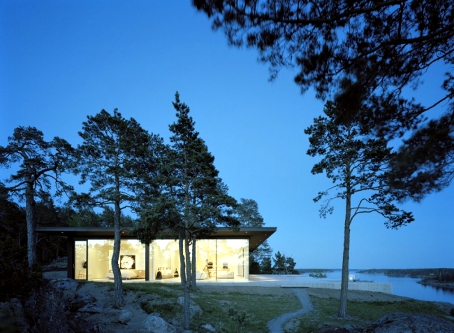 Fully glazed modern holiday villa located on a rocky hill in Sweden