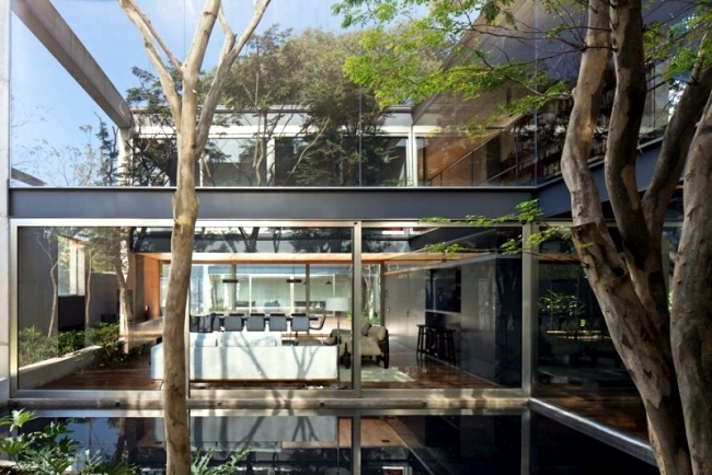 Concrete building with glass facade of Una Arquitetos offers living close to nature