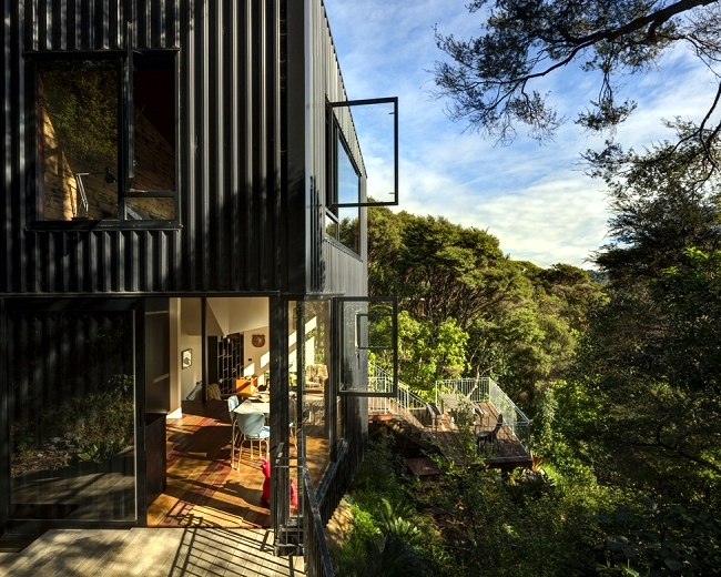 House built on a hillside under a canopy of shade trees