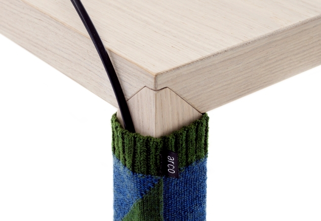 Knitted sock serves as a cable concealment for desktop design